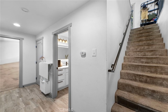 stairs with recessed lighting, wood finished floors, and baseboards
