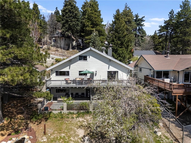 rear view of house with a deck and a chimney