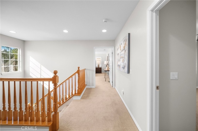 hall featuring recessed lighting, an upstairs landing, carpet, and baseboards