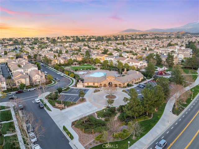 aerial view at dusk featuring a mountain view and a residential view