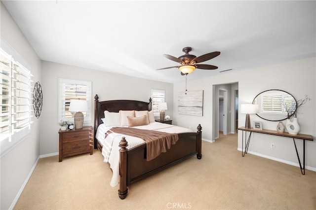 bedroom featuring light colored carpet, baseboards, and multiple windows