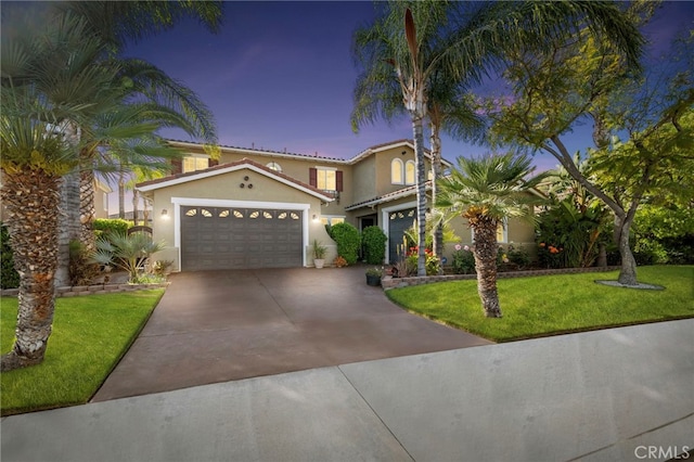 view of front of house with stucco siding, concrete driveway, and a front yard