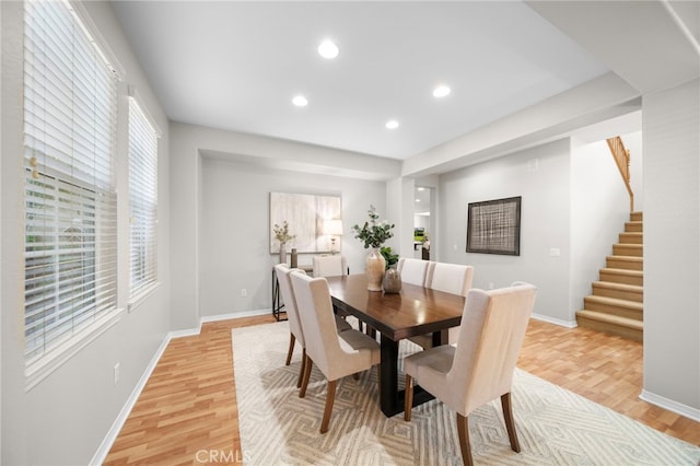 dining space with baseboards, recessed lighting, stairs, and light wood-style floors
