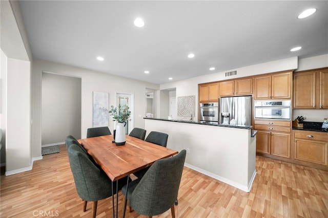 dining space featuring baseboards, visible vents, light wood-type flooring, and recessed lighting