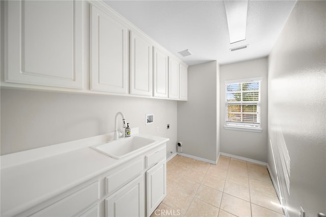 laundry area featuring hookup for an electric dryer, a sink, cabinet space, hookup for a washing machine, and baseboards