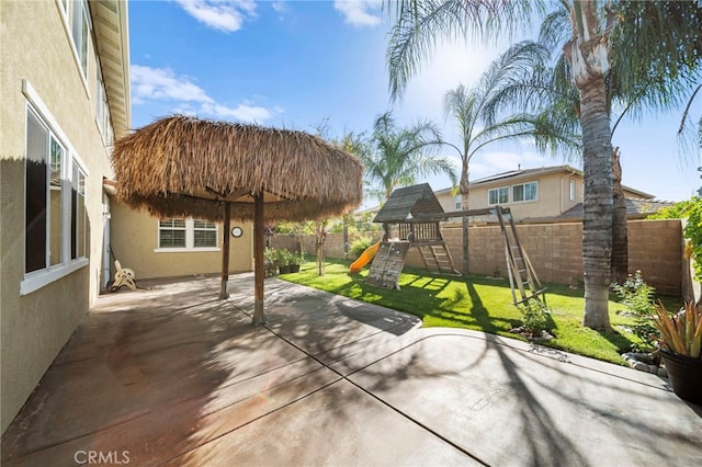 view of patio featuring a playground and a fenced backyard