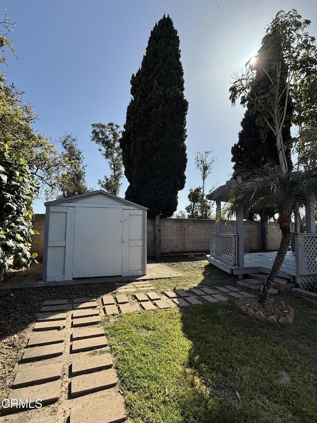 view of yard featuring an outdoor structure, a storage shed, and fence
