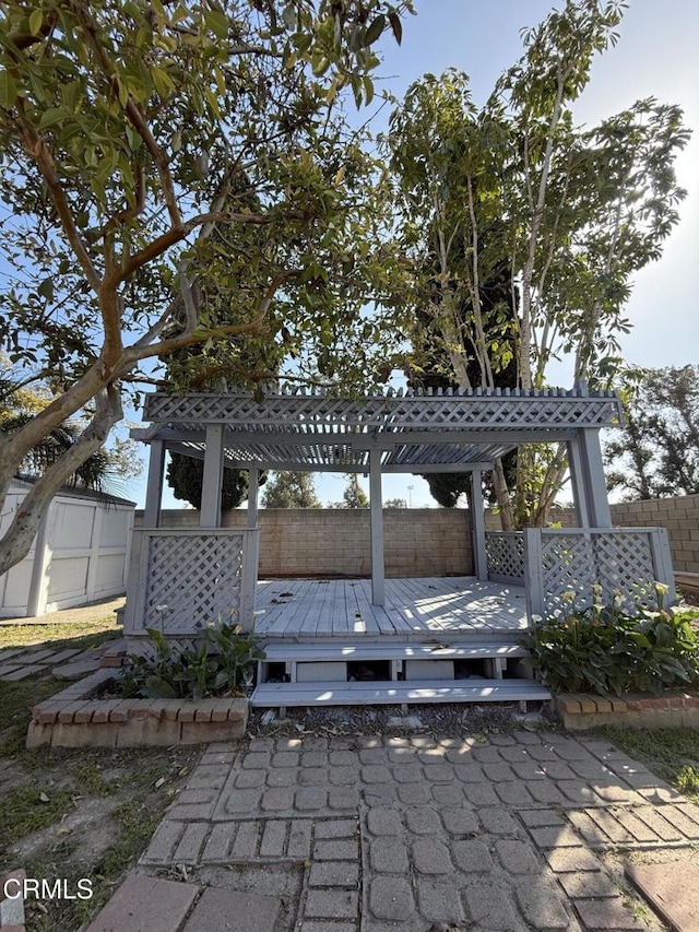 view of patio / terrace featuring a deck, a fenced backyard, and a pergola