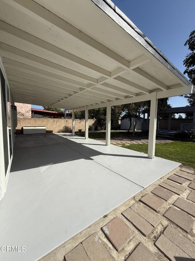view of patio / terrace with fence, a storage shed, and an outbuilding