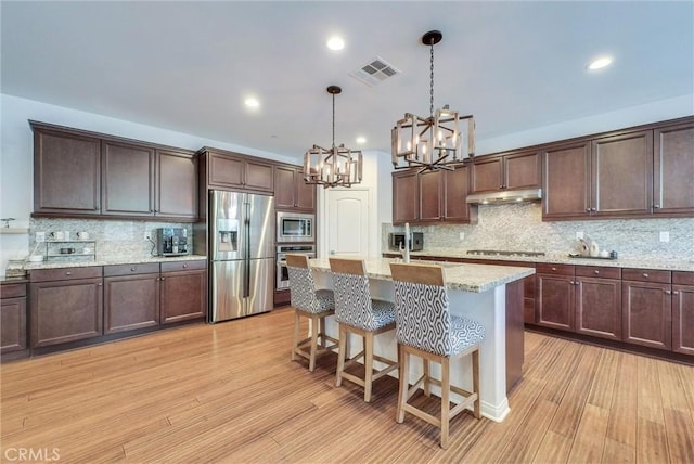 11927 Bunting Cir, Corona, CA 92883 - kitchen with stainless steel appliances, a chandelier, backsplash, light wood-style floors, and recessed lighting