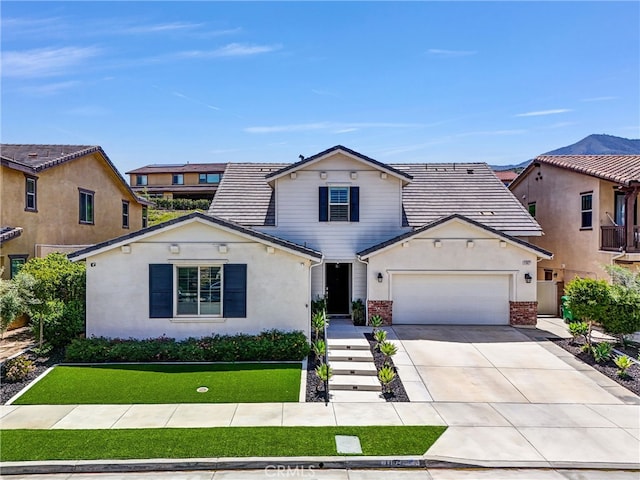 11927 Bunting Cir, Corona, CA 92883 - view of front of property featuring an attached garage, driveway, brick siding, a front yard, and stucco siding