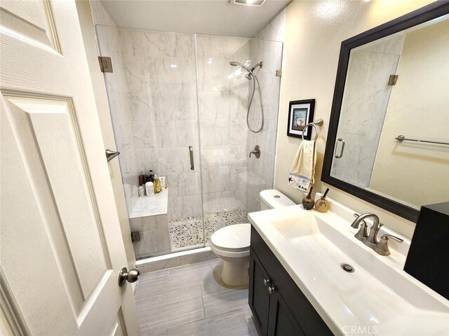 bathroom with toilet, tile patterned floors, a shower stall, and vanity