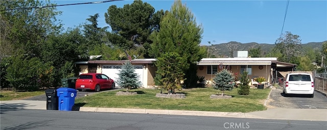 12055 Douglas St, Yucaipa, CA 92399 - single story home with aphalt driveway, stucco siding, an attached garage, a front yard, and a mountain view