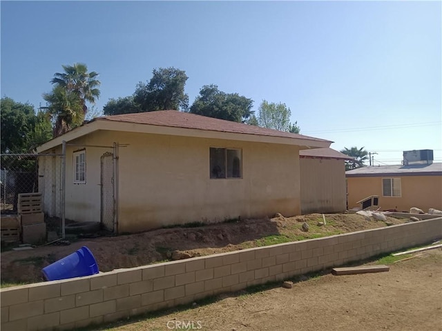 12055 Douglas St, Yucaipa, CA 92399 - view of side of home featuring stucco siding and fence