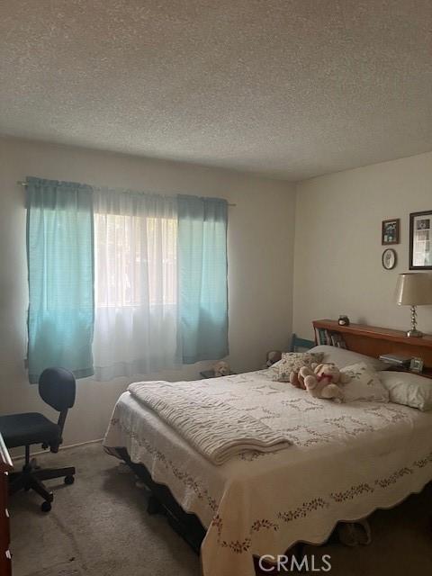 bedroom with carpet floors and a textured ceiling