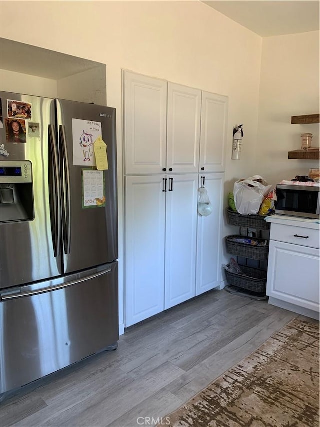 kitchen featuring white cabinets, stainless steel appliances, and light wood finished floors
