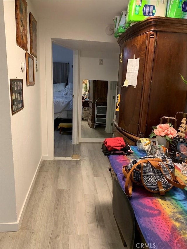 corridor featuring wood finished floors and baseboards