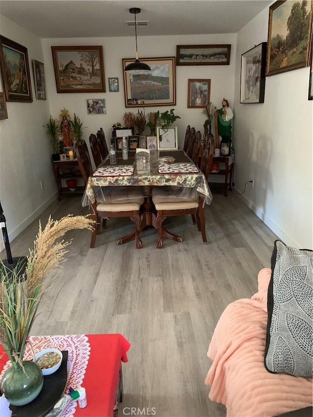dining area with visible vents, wood finished floors, and baseboards