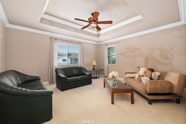 living area with crown molding, ceiling fan, light carpet, and a tray ceiling