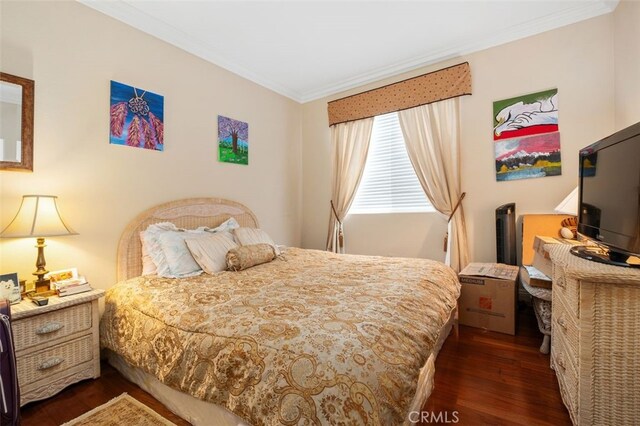 bedroom featuring crown molding and dark wood-type flooring