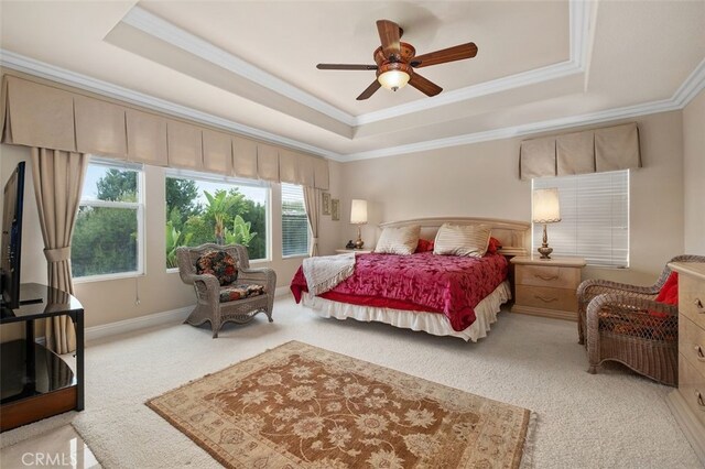 bedroom with light colored carpet, ornamental molding, a ceiling fan, and a tray ceiling