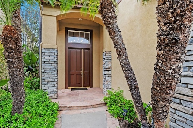 property entrance with stone siding and stucco siding