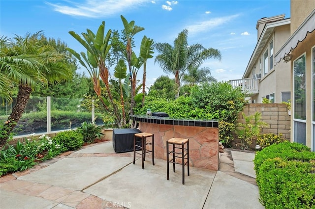 view of patio / terrace with outdoor dry bar and fence