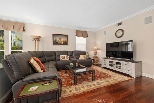 living room featuring dark wood finished floors, visible vents, crown molding, and baseboards