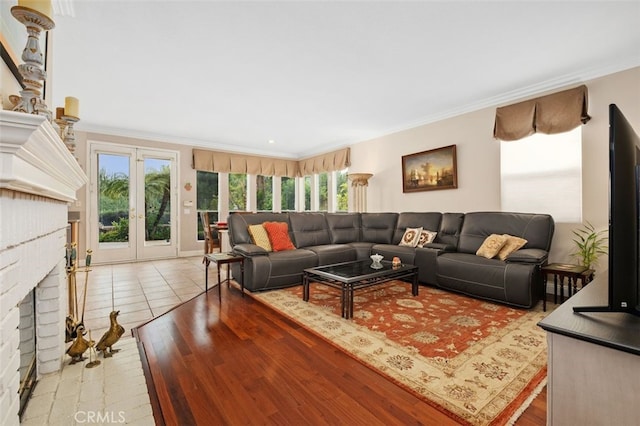 living room with a fireplace, french doors, and crown molding