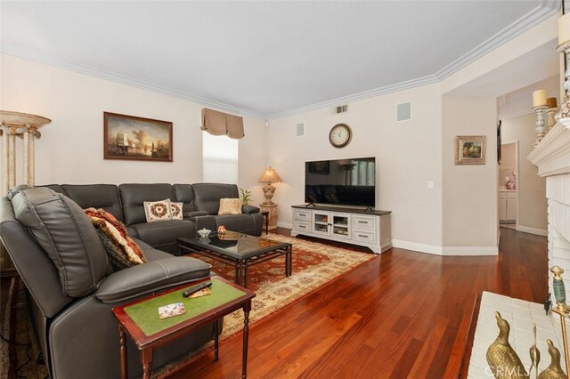 living room featuring baseboards, visible vents, dark wood-style flooring, and crown molding