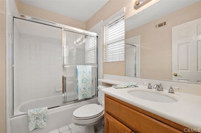 full bathroom featuring toilet, combined bath / shower with glass door, visible vents, and vanity