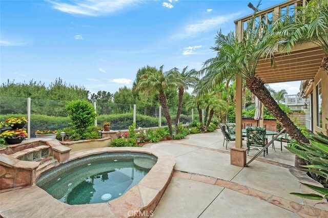 view of pool with fence, an in ground hot tub, and a patio area
