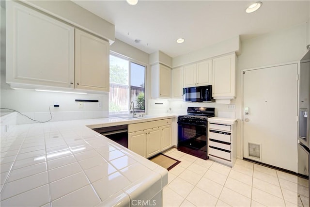 32851 Naples Ct, Temecula, CA 92592 - kitchen with white cabinetry, a sink, tile counters, black appliances, and light tile patterned flooring