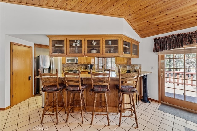 bar featuring lofted ceiling, stainless steel appliances, light tile patterned floors, and wood ceiling