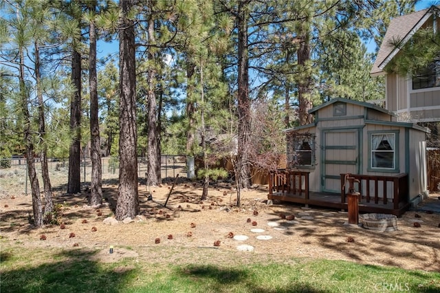 view of yard with an outdoor structure, a shed, and fence