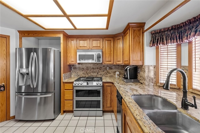 kitchen featuring decorative backsplash, light tile patterned floors, stainless steel appliances, and a sink