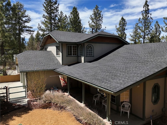 view of home's exterior with roof with shingles and fence