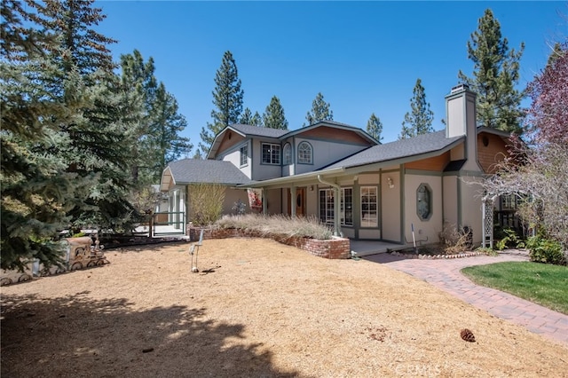 exterior space featuring a chimney and stucco siding