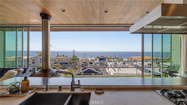 interior space with a sink, a water view, and a balcony