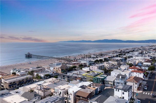 aerial view at dusk featuring a water and mountain view