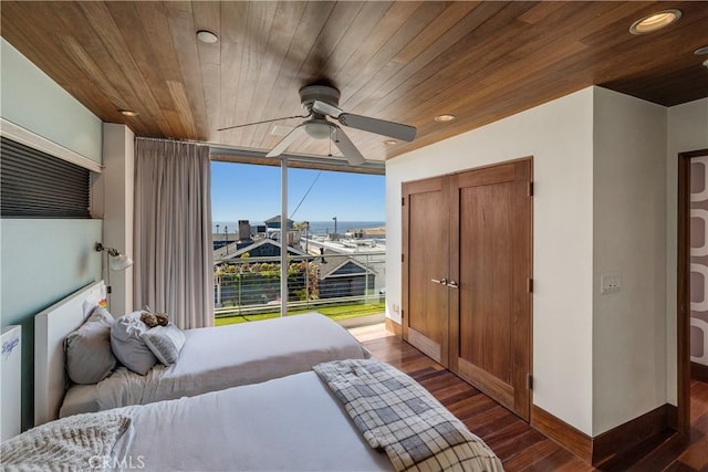 bedroom featuring baseboards, dark wood-style floors, and wooden ceiling