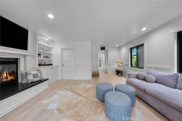 1012 10th St, Manhattan Beach, CA 90266 - living area featuring a glass covered fireplace, wooden ceiling, built in shelves, and light wood-style floors