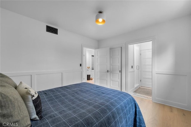 1012 10th St, Manhattan Beach, CA 90266 - bedroom featuring connected bathroom, visible vents, wood finished floors, and a wainscoted wall