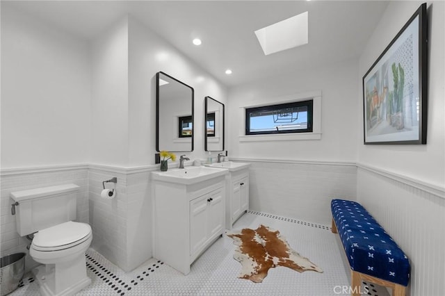 1012 10th St, Manhattan Beach, CA 90266 - bathroom featuring toilet, a skylight, wainscoting, and tile patterned floors