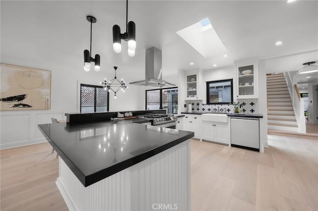 1012 10th St, Manhattan Beach, CA 90266 - kitchen featuring island range hood, dark countertops, gas stove, white cabinets, and light wood finished floors