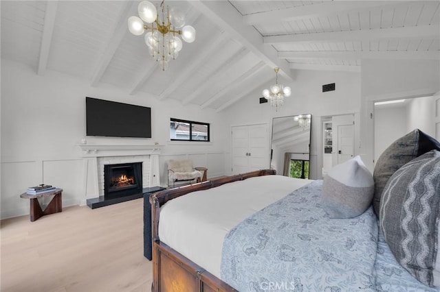 1012 10th St, Manhattan Beach, CA 90266 - bedroom featuring an inviting chandelier, a fireplace, light wood-style floors, vaulted ceiling with beams, and visible vents