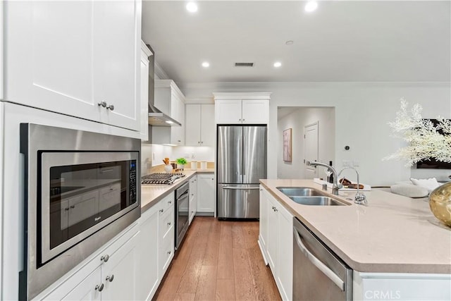 kitchen featuring white cabinets, appliances with stainless steel finishes, light countertops, and a sink