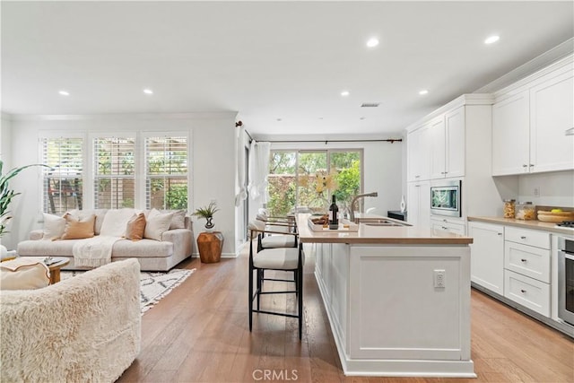 kitchen featuring appliances with stainless steel finishes, a kitchen island with sink, recessed lighting, and a sink