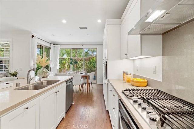 kitchen with a sink, stainless steel appliances, under cabinet range hood, visible vents, and plenty of natural light