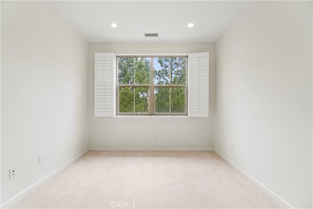 empty room with visible vents, baseboards, and light carpet
